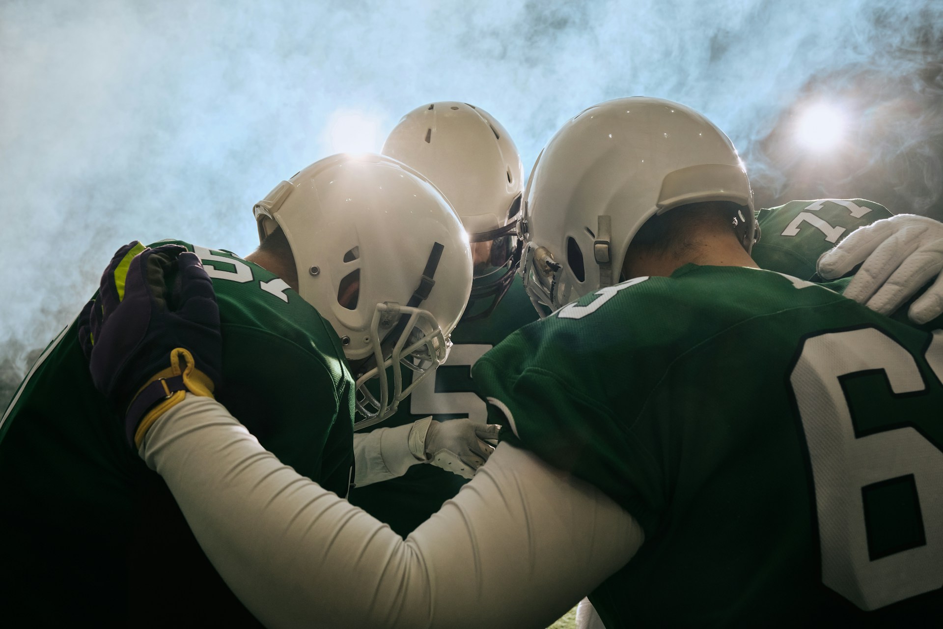 college football athletes in a huddle